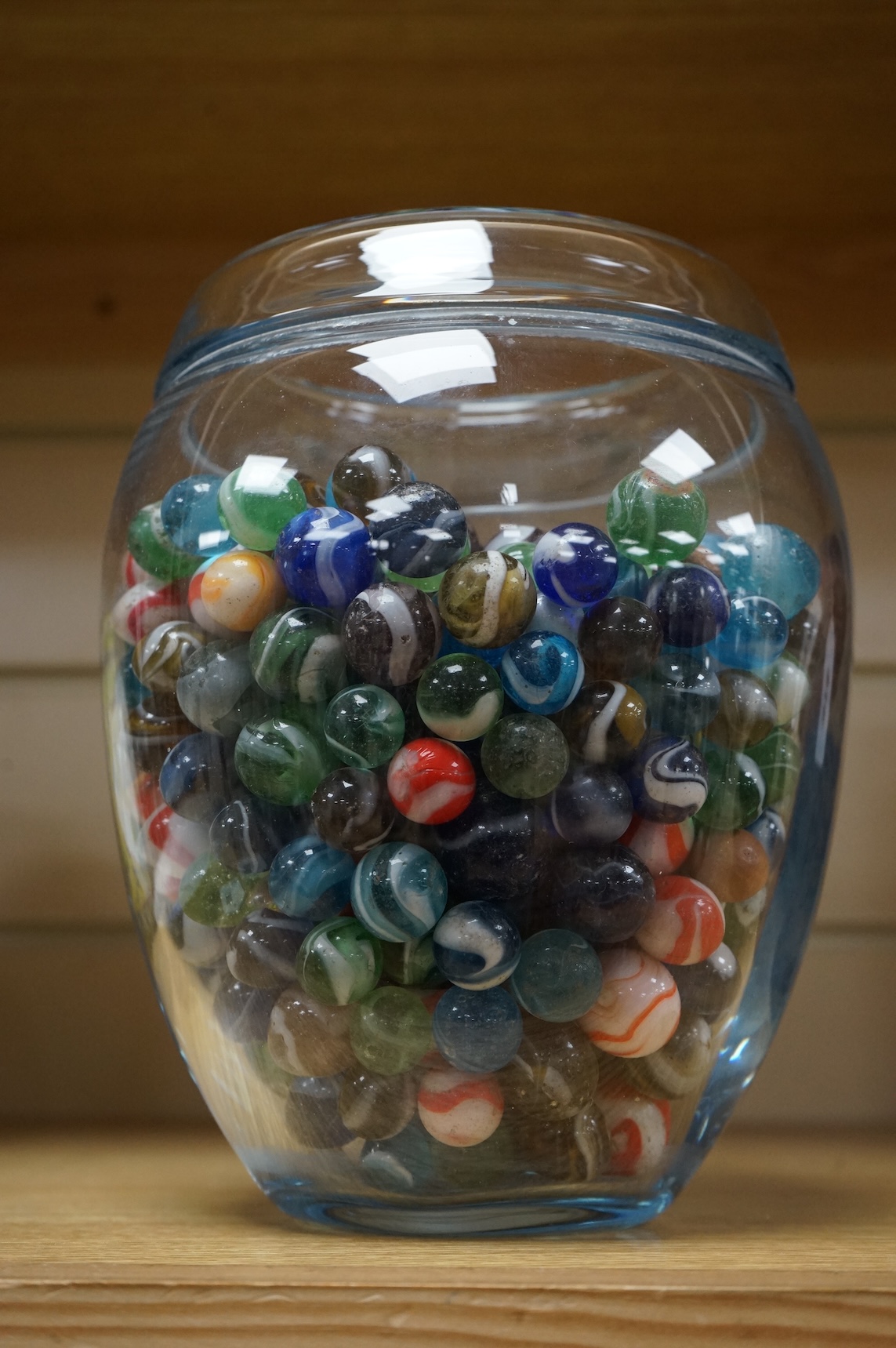 A glass vase possibly by Holmgaard, containing a large collection of late 19th/early 20th century glass marbles, 19cm high